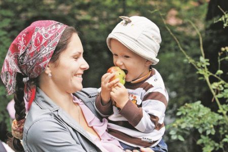 Ребенок ест яблоко, не пораженное болезнями и вредителями